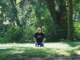 Male officer in field meditating.